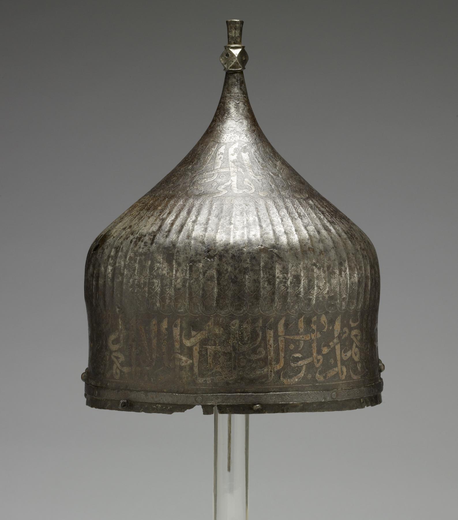 A warrior would have worn this helmet over a cloth turban. He would have been confident of being safeguarded in battle by the writing around the helmet's rim. The inscription from the Qur'an is garbled, however, indicating that its Iranian maker may not have known Arabic. Yet the presence of Arabic writing apparently was thought to be enough to invoke the protective power of God's word. This helmet once belonged to the royal arsenal in Istanbul, Turkey. It was probably part of the war booty amassed by the Ottoman Dynasty during the many wars between Turkey and Iran. Later, it was owned by the French painter Jean-Léon Gérôme, who traveled throughout the Near East and painted many scenes of Muslim life.
