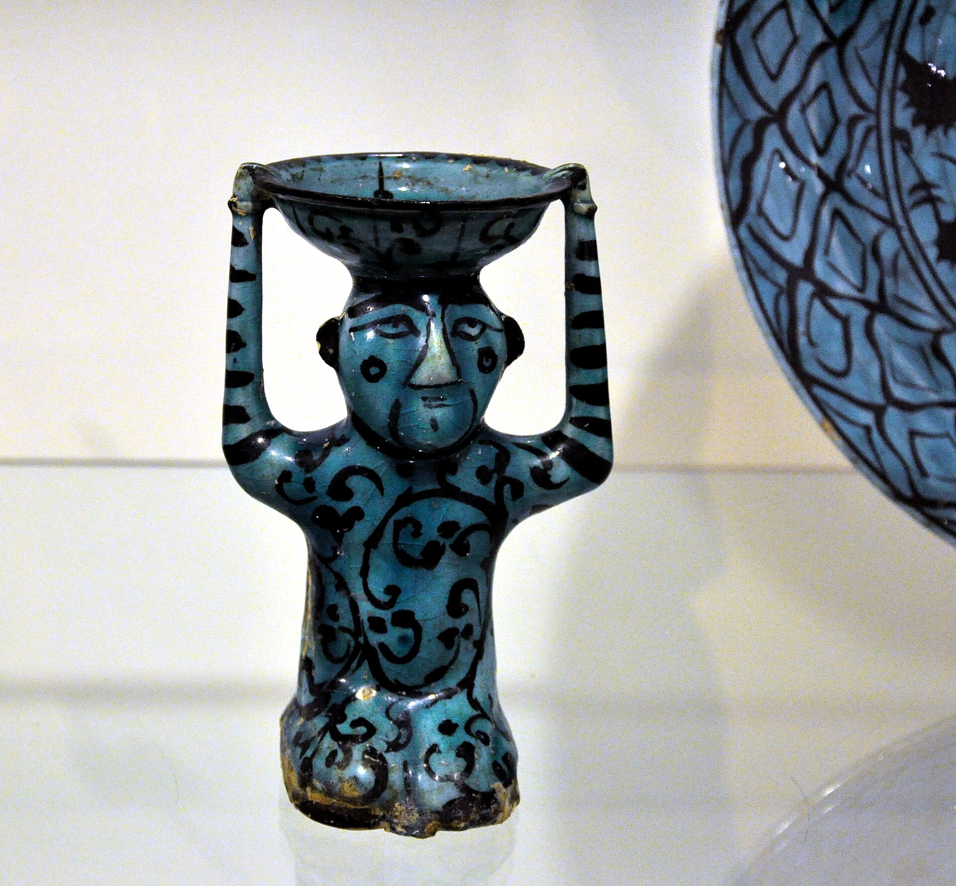 Ceramic figurine, Iran or Syria, 13th century AD. Ceramic with transparent turquoise glaze and black painting; Museum für Angewandte Kunst Frankfurt am Main, Inv. No. 13166