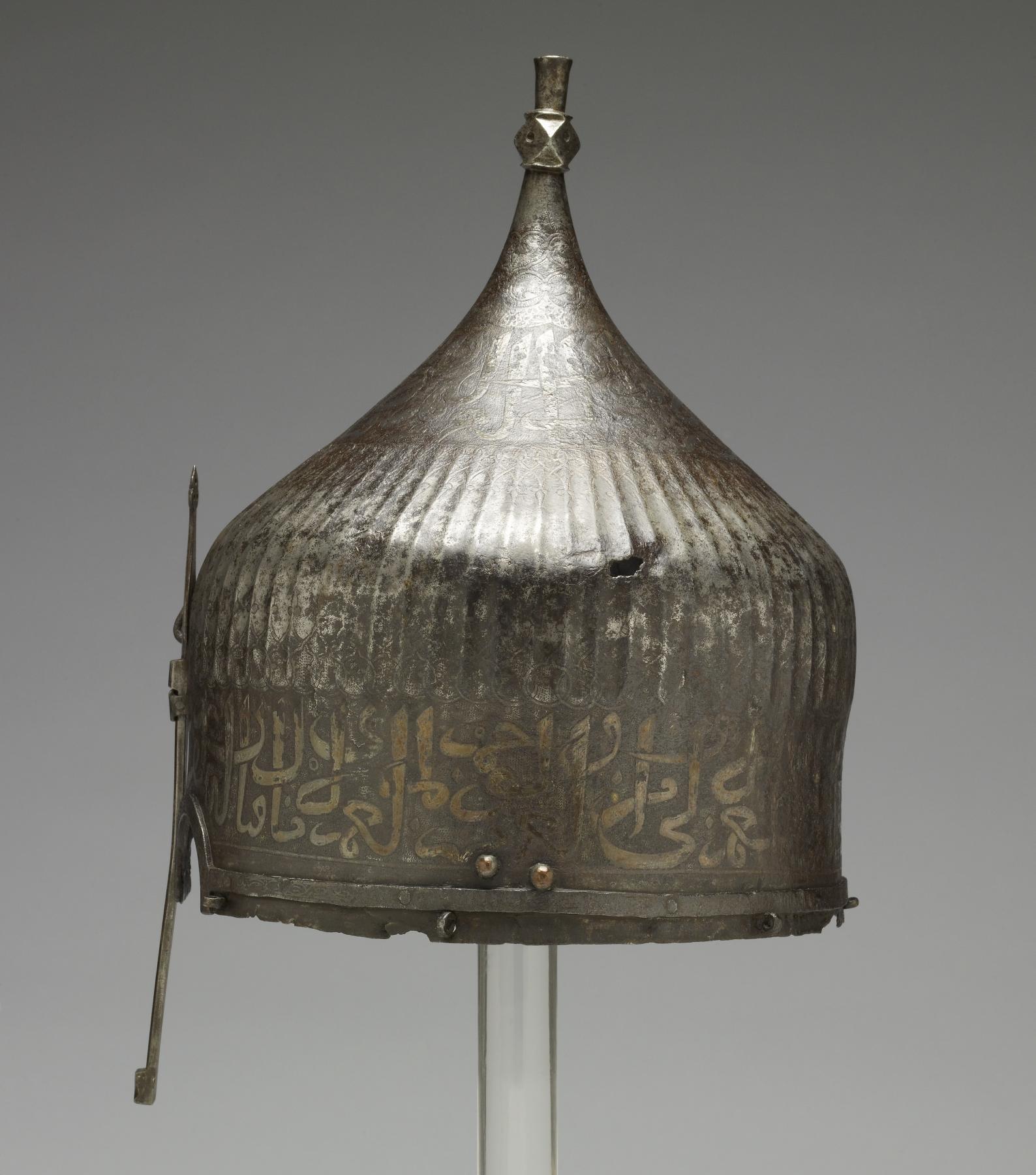 A warrior would have worn this helmet over a cloth turban. He would have been confident of being safeguarded in battle by the writing around the helmet's rim. The inscription from the Qur'an is garbled, however, indicating that its Iranian maker may not have known Arabic. Yet the presence of Arabic writing apparently was thought to be enough to invoke the protective power of God's word. This helmet once belonged to the royal arsenal in Istanbul, Turkey. It was probably part of the war booty amassed by the Ottoman Dynasty during the many wars between Turkey and Iran. Later, it was owned by the French painter Jean-Léon Gérôme, who traveled throughout the Near East and painted many scenes of Muslim life.