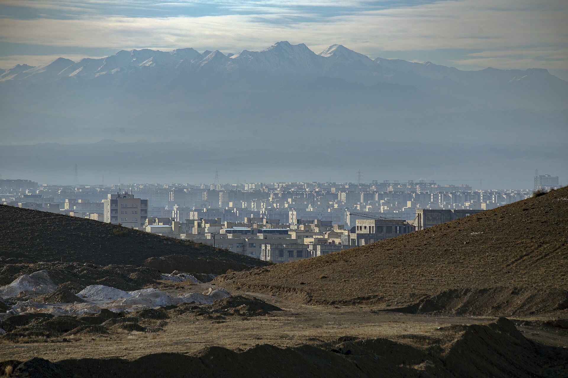 Qom is located beside the desert at 140 km south of Tehran with the height of 930 m above the sea level in an arid region. It enjoys a desert and semi-desert climate. Summer is warm and arid and winter is nearly cold in this city. Qom consists of 5 parts as "Jafarabda", "Khalajestan", "Salafchegan", "Kahak", "Markazi", one city and 9 rural districts. This city is the 8th populous city after Tehran, Mashhad, Isfahan, Tabriz, Karaj, Shiraz, Ahvaz and second religious city after Mashhad and also one of the main centers of Silk Carpet, Sweets and Sohan production in Iran and all around the world located among Iran transportation roads which connect the industrial cities to Tehran, on one hand, and link the southern provinces and cities of Iran to the northern ones, on the other hand. Qom, one of the most significant desert towns, is of the main poles of developing pilgrimage tourism in Iran.
